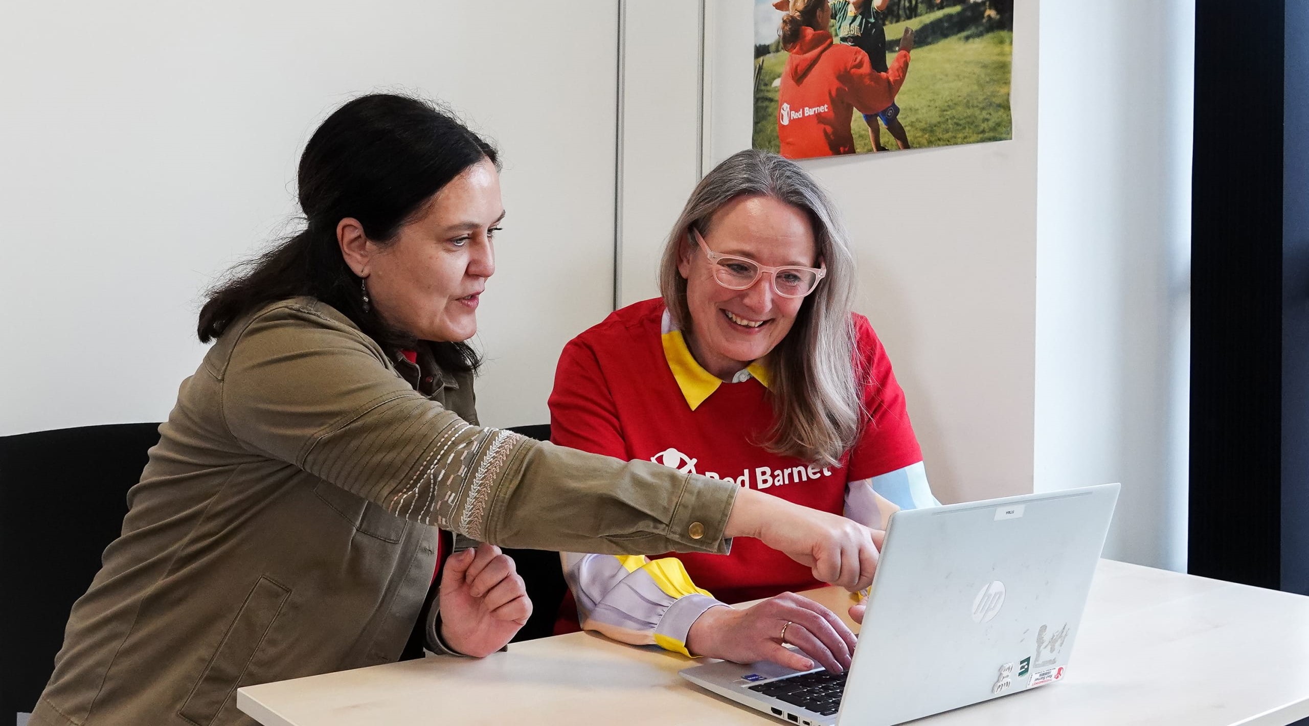 To Red Barnet-frivillige kigger på pc