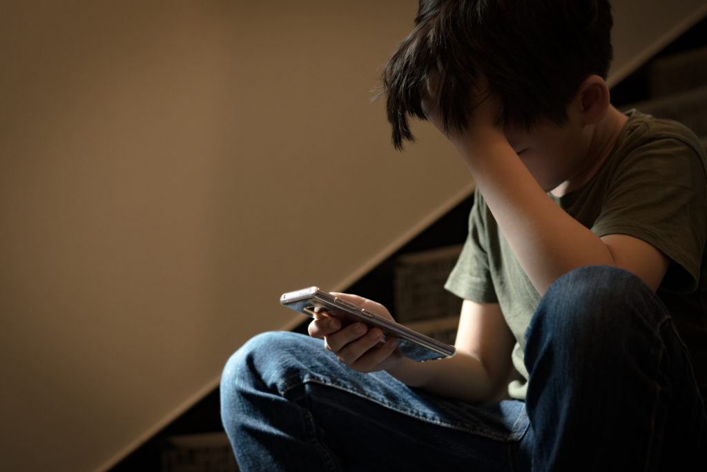 Billede af anonym dreng på sin telefon