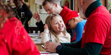 Frivillig og børn rundt om et bord