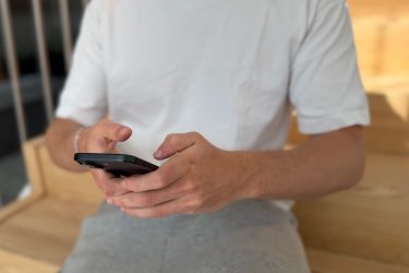 Teenager med mobil ved trappe