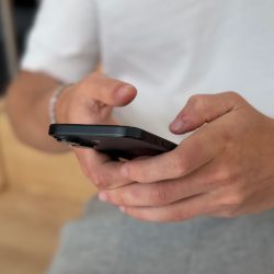 Teenager holder mobil med to hænder